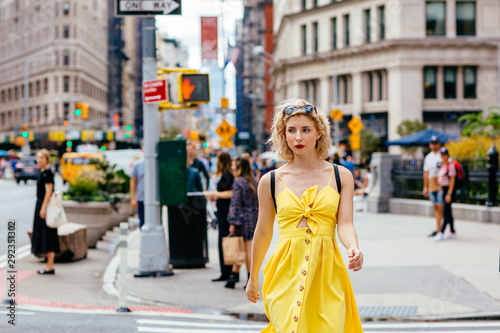 Woman in yellow dress walking on a busy New York street, United States of America