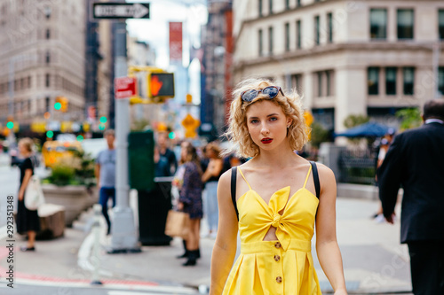 Woman in yellow dress walking on a busy New York street