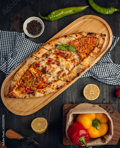 Mix turkish flatbread pide with minced meat, cheese, roasted meatcubes and vegetable photo