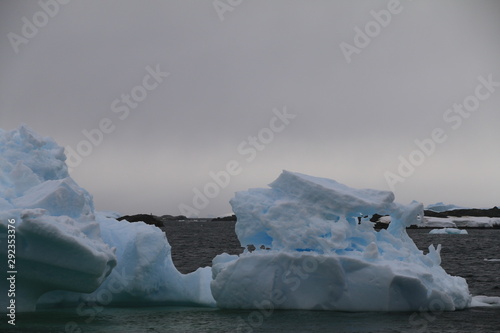 potężne bryły lodu dryfujące na wodach koła podbiegunowego u wybrzeży antarktydy