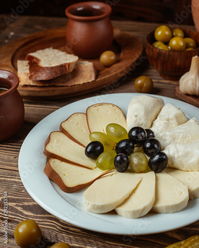 Traditional setup for cheese plate with smoked, white, goat cheese, grapes
