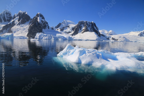 wystający ponad taflę wody wierzchołek góry lodowej przy wybrzeżu antarktydy w słoneczny dzień