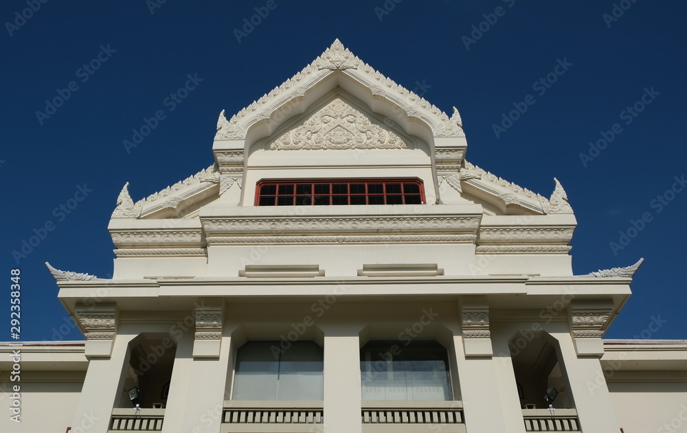 Thai traditional building soars into deep blue sky