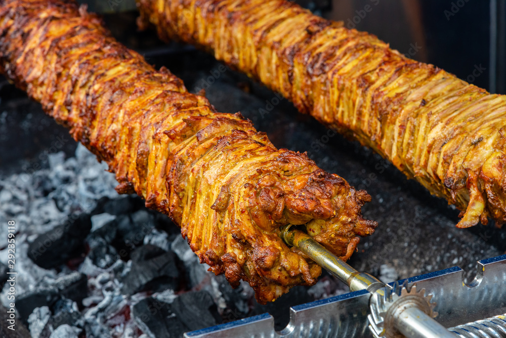 Foto de A rotating spit roast of meat over hot coals as used to make ...