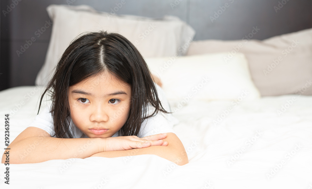 Girls in pajamas are lying in bed. Sad and unhappy expression in the bedroom at home. Girls in pajamas are lying in bed. Sad and unhappy expression in the bedroom at home.