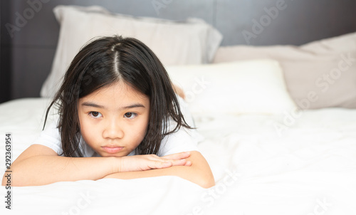 Girls in pajamas are lying in bed. Sad and unhappy expression in the bedroom at home.