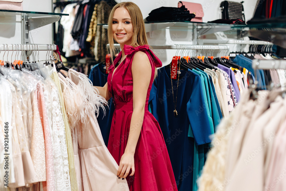 Young woman choosing clothes on a rack in a showroom Young woman choosing clothes on a rack in a showroom