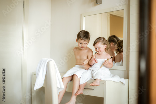 Cute toddler boy brushing his teeth after having a bath. Boy after evening before sleep rituals.