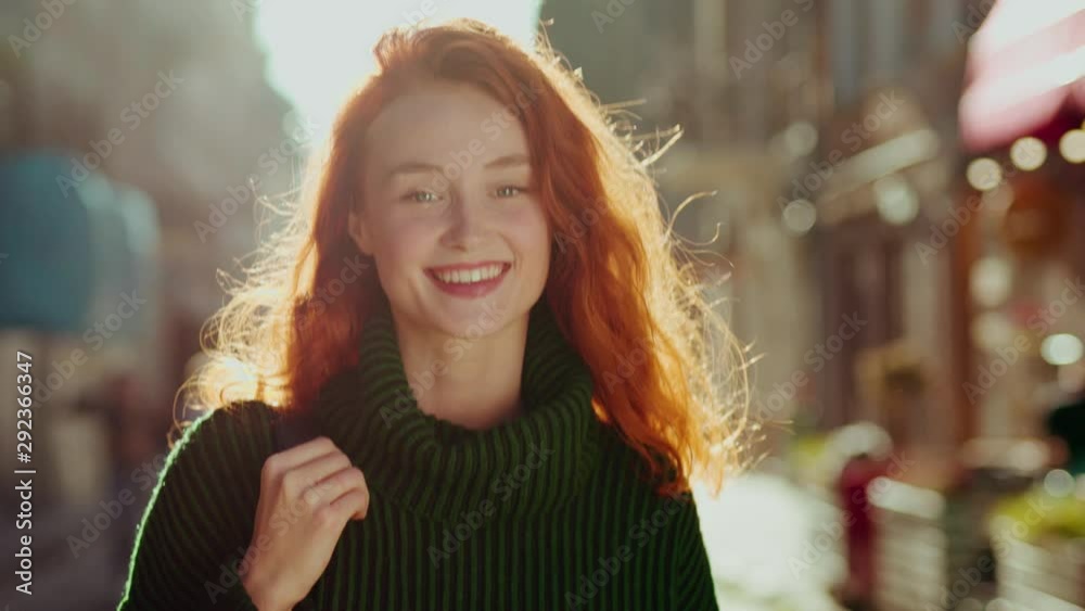 Portrait of charming young woman with curly red hair in a bright ...