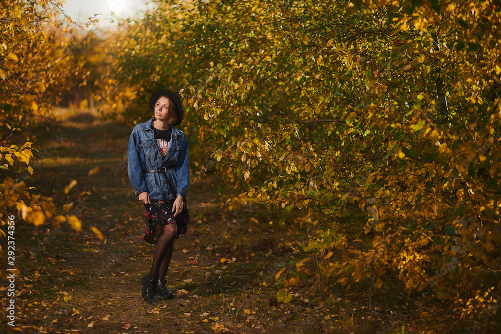 A young girl walks through the autumn forest with yellow leaves A young girl walks through the autumn forest with yellow leaves