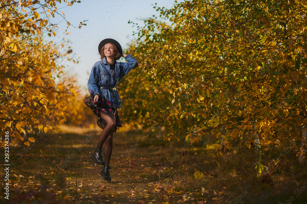 A young girl walks through the autumn forest with yellow leaves A young girl walks through the autumn forest with yellow leaves