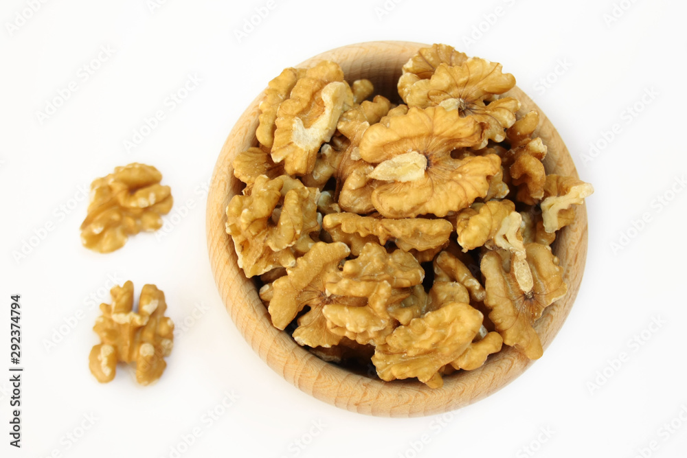 Wooden bowl filled with walnuts on a white background