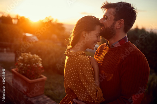 romantic man and woman kissing at sunset. photo