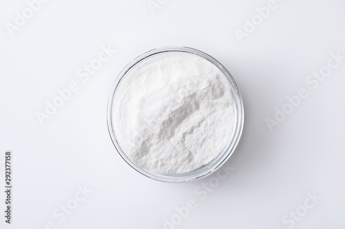 Baking soda in a jar and bowl on a white table
