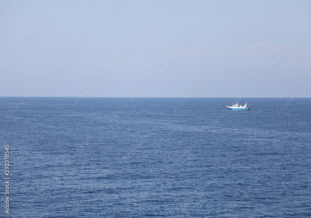 water of the ocean and the blue sky with fishing boat