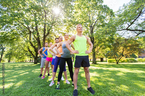 fitness, sport and healthy lifestyle concept - group of happy friends or sportsmen at summer park or boot camp
