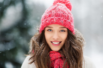 people, season and christmas concept - portrait of happy smiling teenage girl or young woman outdoors in winter park