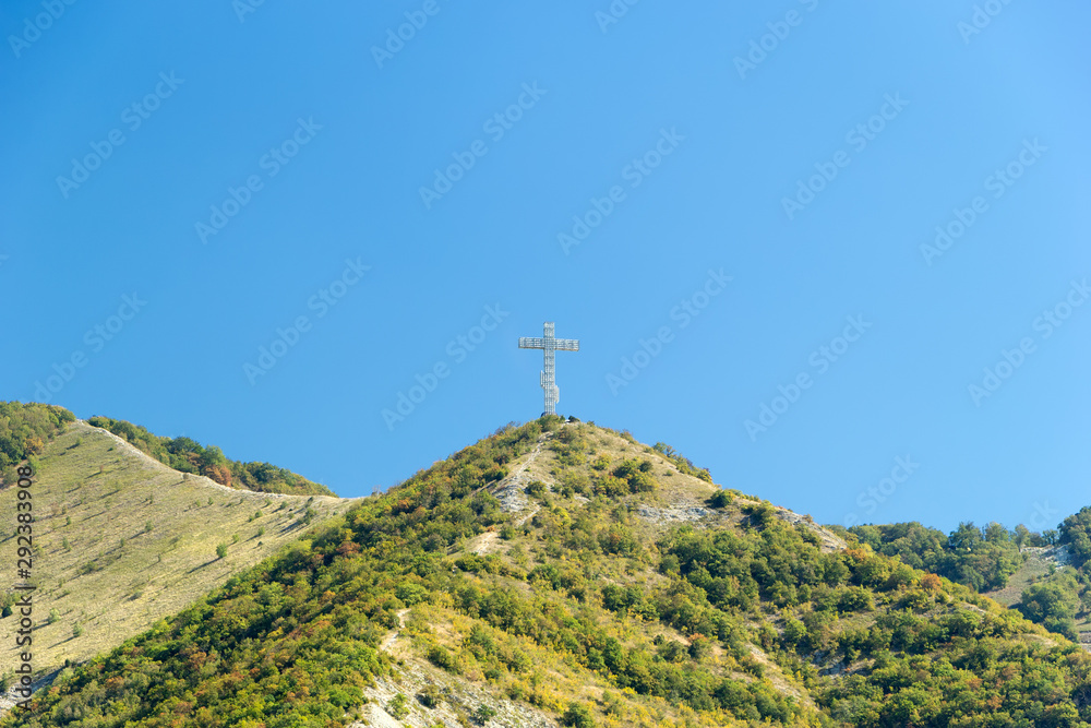 Gelendzhik, Krasnodar region, Russia, September 10. Orthodox worship cross on the hill of Caucasian mountains with chapel in foundation. Day time.