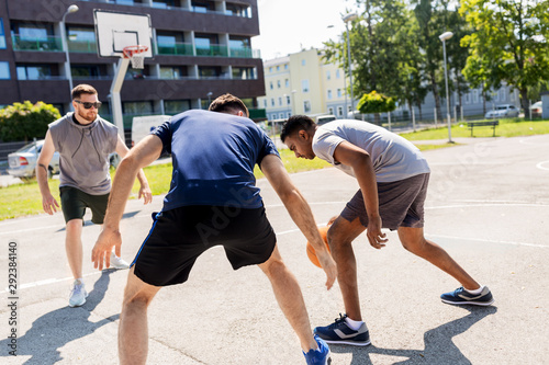 sport, leisure games and male friendship concept - group of men or friends playing street basketball