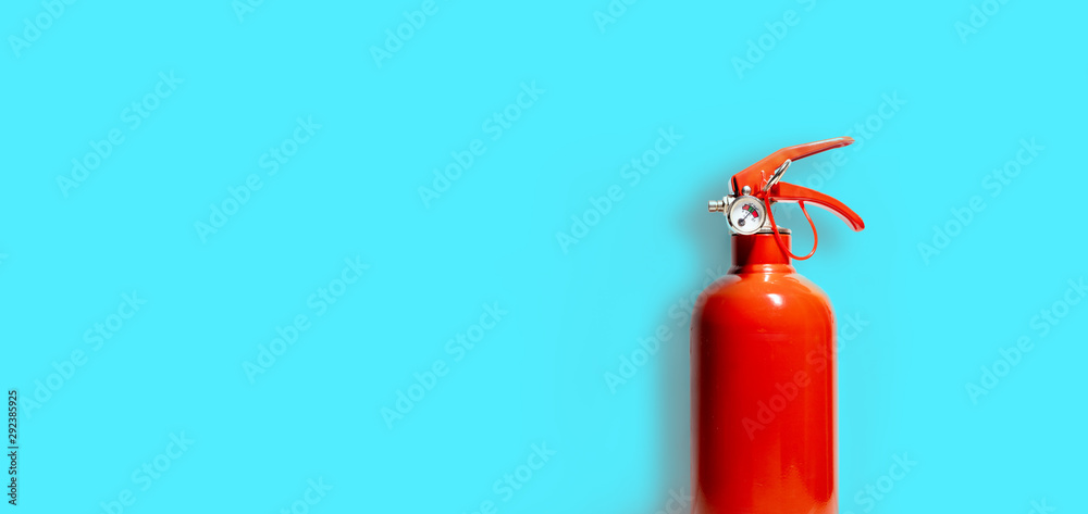 Obraz premium Red Fire Extinguisher and its shadow isolated on blue-green color background - Copy space - Business Concept