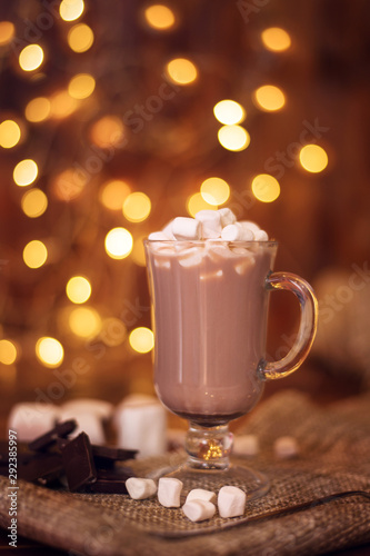 Cacao drink in a glass with marshmallow on the background of bokeh lights, Christmas drink