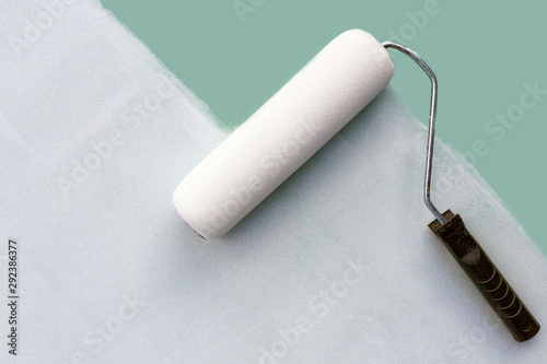 paint roller paints the wall white