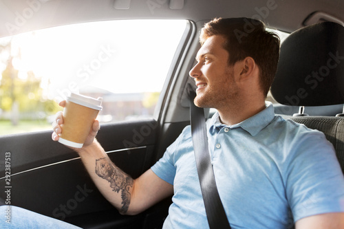 transport and people concept - man drinking takeaway coffee on back seat of taxi car