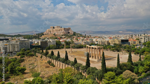 Aerial photo of iconic pillars of Temple of Olympian Zeus and world famous Acropolis hill with masterpiece Parthenon on top at the background, Athens historic centre, Attica, Greece
