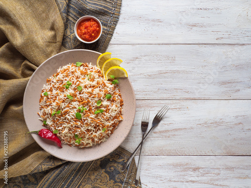 Turkish rice pilaf with orzo in a plate on a white wooden background. Top view. 