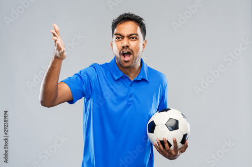 sport, leisure games and success concept - angry emotional indian man or football fan with soccer ball over grey background