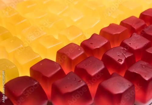 Red and yellow cube shaped jelly candy. Candy background.
