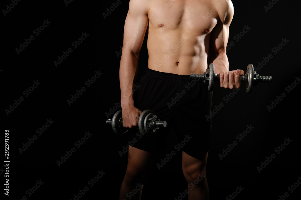 athletic muscular bodybuilder man with naked torso six pack abs working out with dumbbell. fitness  exercise concept