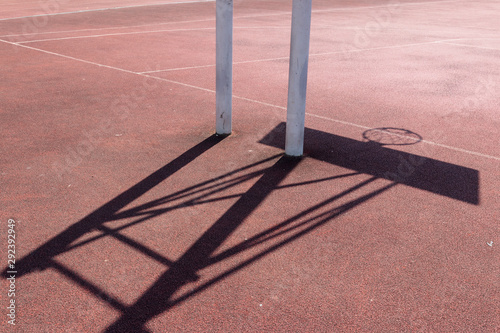 Chadow of basketball hoop at the red playground photo