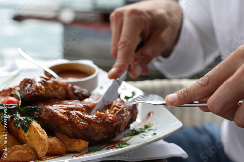Man having lunch close up, Grilled pork spare ribs photo