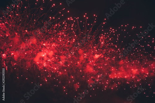 Fireworks background. Red lights. Fireworks display on dark sky background.