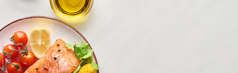 top view of raw salmon steak with corn, lemon and tomatoes on plate near oil on marble table, panoramic shot top view of raw salmon steak with corn, lemon and tomatoes on plate near oil on marble table, panoramic shot
