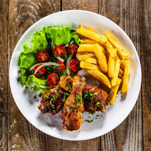 Grilled chicken drumsticks with french fries and vegetables