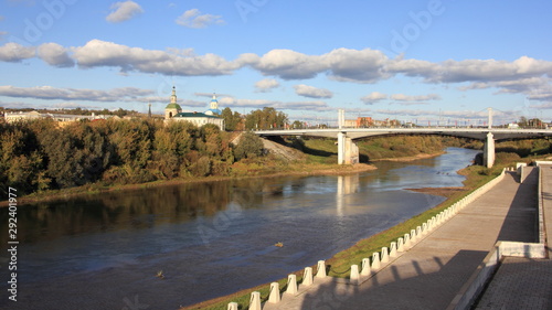 Smolensk, Russia, Dnepr river, Uspensky Bridge, City embankment and St. Nicholas Church on horizon in autumn sunny day on blue sky background, wide view from observation deck © Ilya