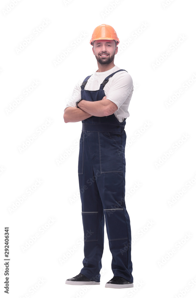 in full growth. smiling man in overalls and a safety helmet in full growth. smiling man in overalls and a safety helmet