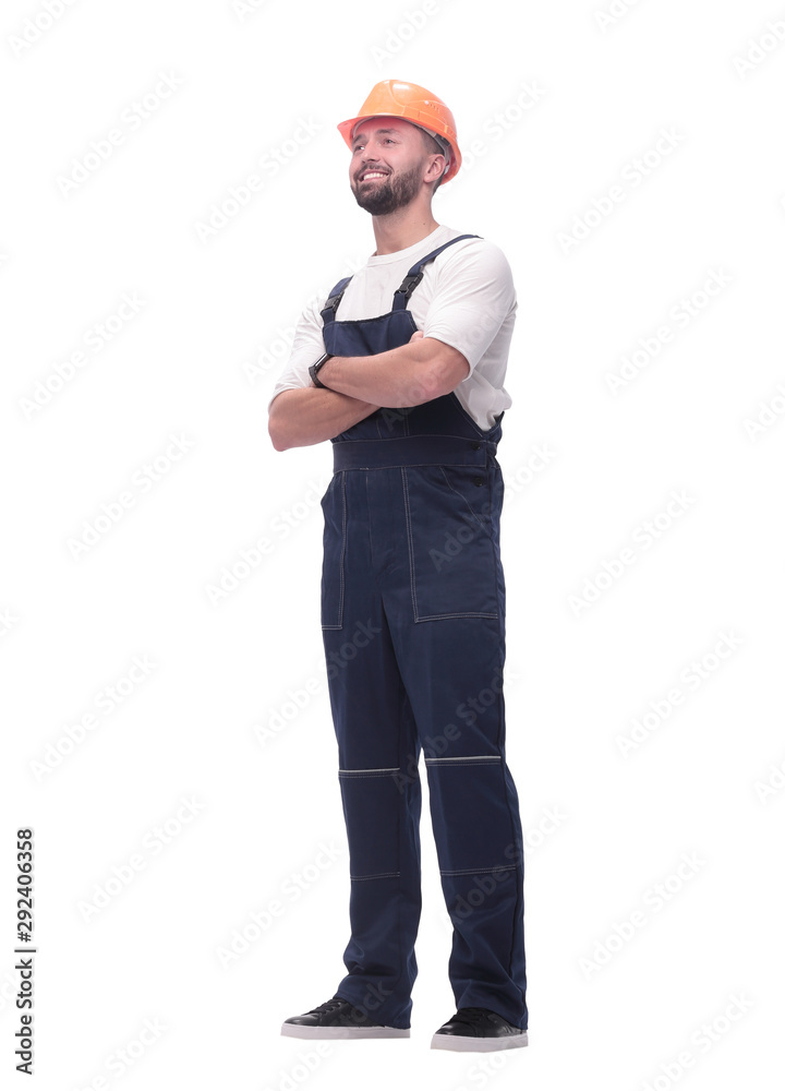 in full growth. smiling man in overalls and a safety helmet in full growth. smiling man in overalls and a safety helmet