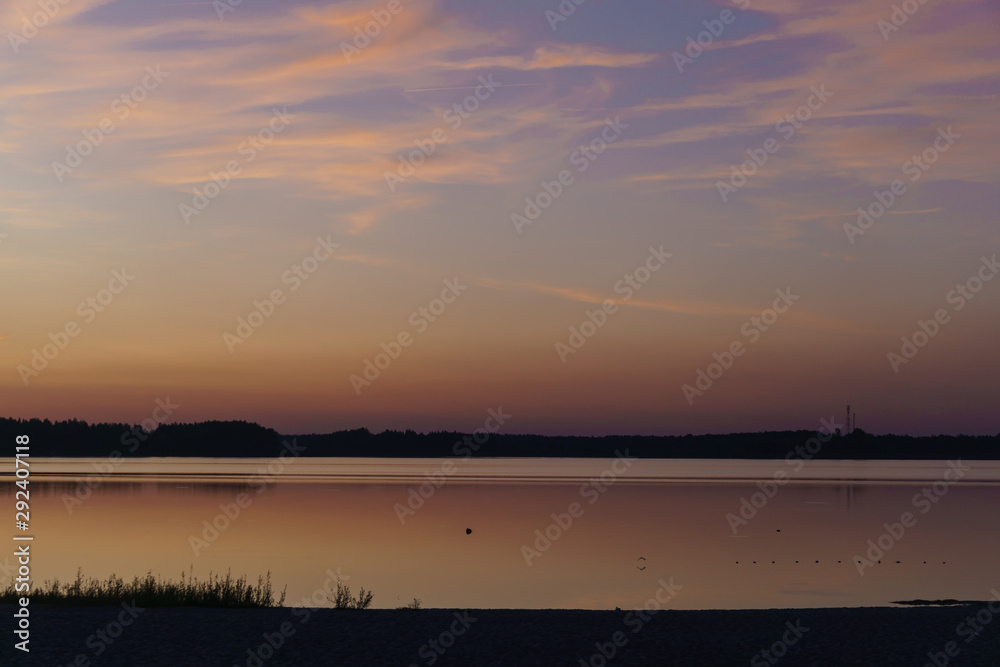 Beautiful sunny sunset over the lake. Evening landscape.