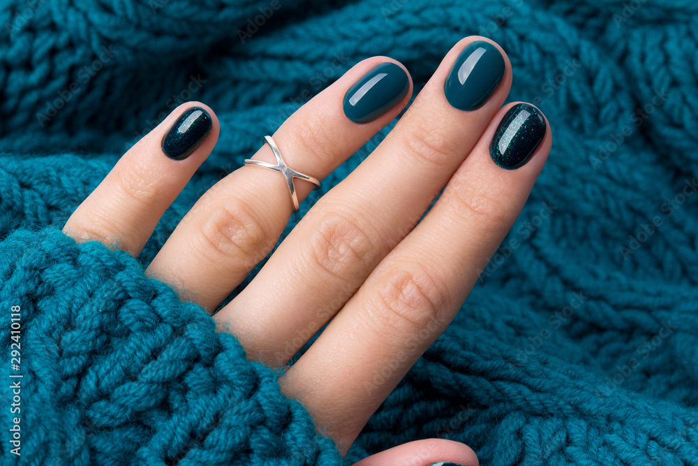 Fototapeta Manicured woman's hand in warm wool turquoise sweater