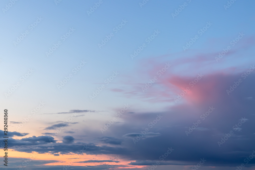 Colorful sunrise with clouds, light rays in blue sky