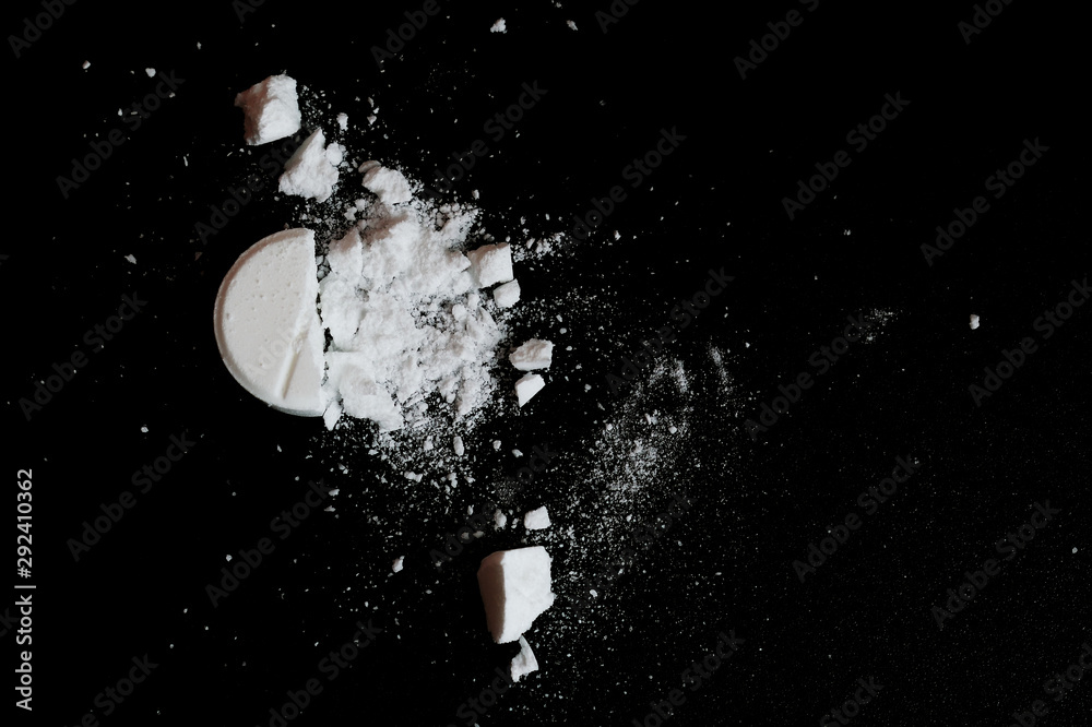 White squashed tablet pill on black background. Top view - obrazy, fototapety, plakaty 