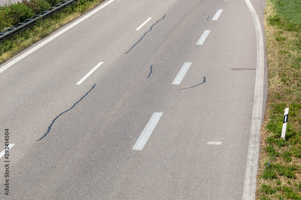 Driveway to a little German highway with tire tracks and damages Driveway to a little German highway with tire tracks and damages