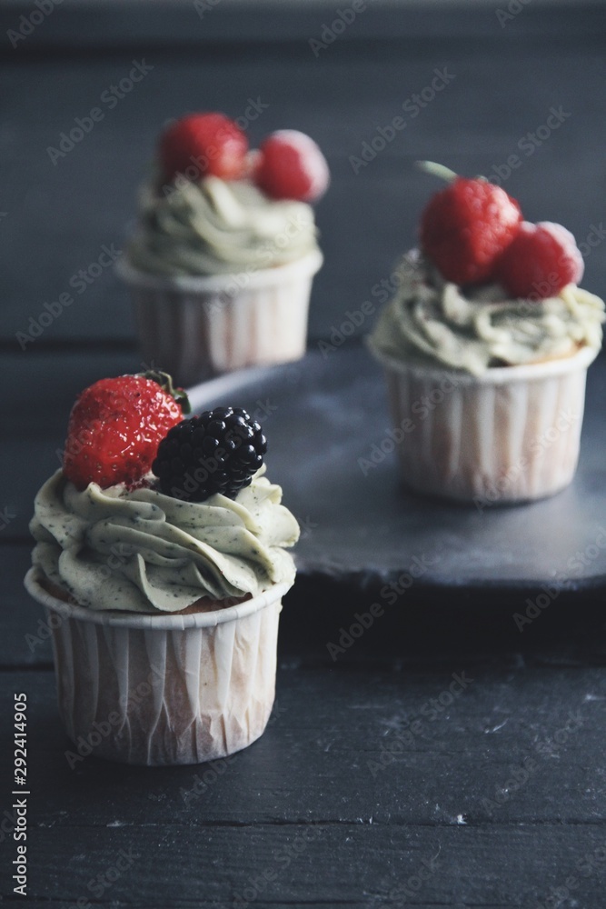 Strawberry cupcakes on wooden black kitchen background