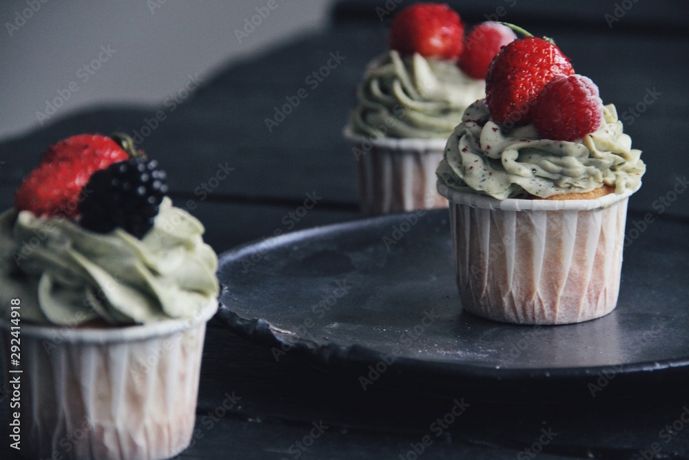 Strawberry cupcakes on wooden black kitchen background