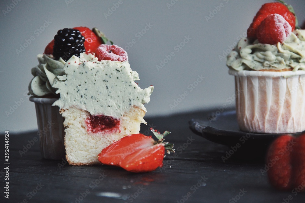 Strawberry cupcakes on wooden black kitchen background