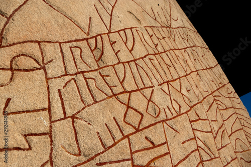 Close up of a Swedish rune stone with red runes 