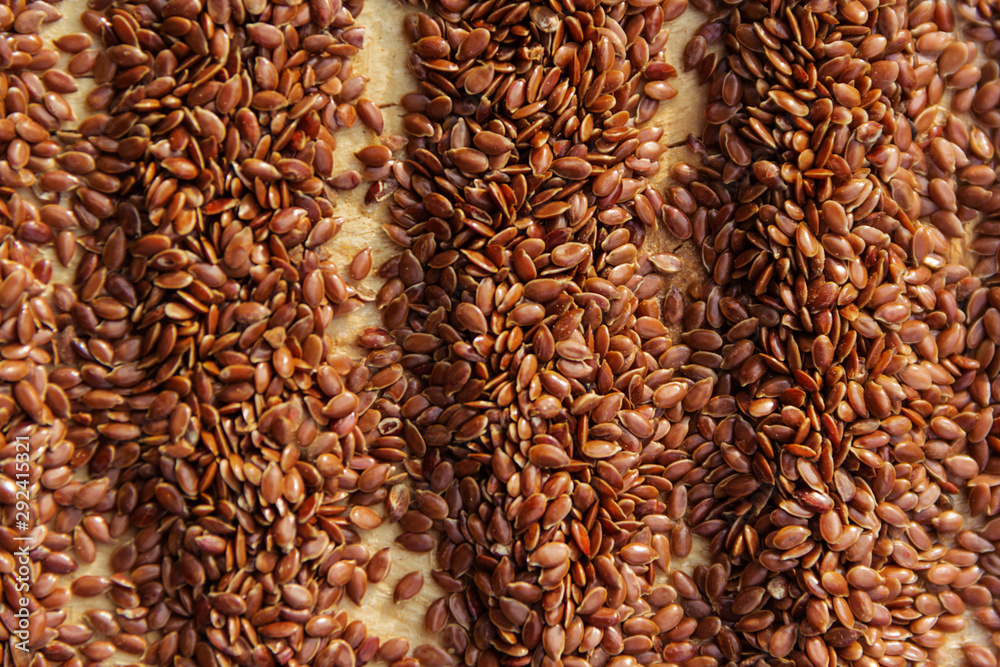 Obraz premium Brown flax seeds give flaxseed oil background